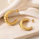 siknakit-aurelia-twist-zlati-teksturirani-hoop-uhani-travertin-saten-podlaga