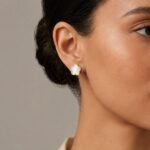 siknakit-clover-ivory-zlati-vticni-uhani-deteljica-z-belim-vlozkom-closeup-na-usesu
