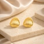siknakit-golden-ripple-stud-zlati-vticni-uhani-z-valovitim-reliefom-produktna-kamnita-podlaga