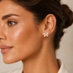 siknakit-ivory-flutter-zlati-vticni-uhani-metulj-ivory-emajl-closeup-na-usesu