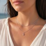 siknakit-silver-drop-duo-srebrna-dvojna-verizica-s-kapljicastim-obeskom-closeup-na-vratu-ob-morju