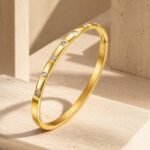siknakit-zlata-bangle-zapestnica-s-cirkoni-lumiere-facet-bangle-gold-travertin-podlaga