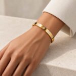 sik-nakit-maison-fleur-bangle-zlata-bangle-zapestnica-s-cvetlicnimi-detajli-in-cirkoni-closeup-na-zapestju-bel-rokav