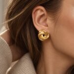 sik-nakit-sculpted-swirl-gold-zlati-skulpturalni-vticni-uhani-closeup-na-usesu